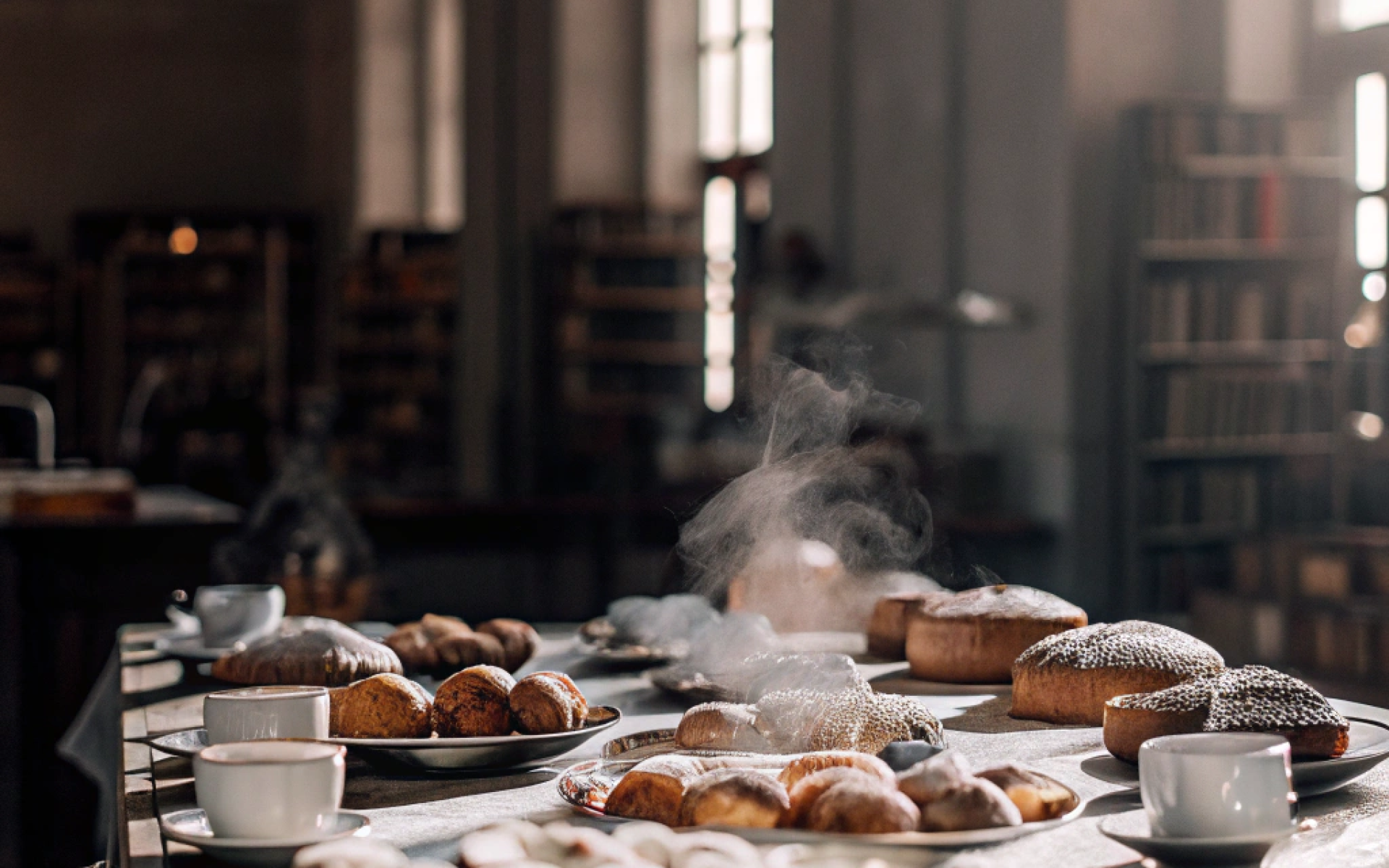 Tisch in der Bücherei mit Kaffee und Mehlspeisen drauf